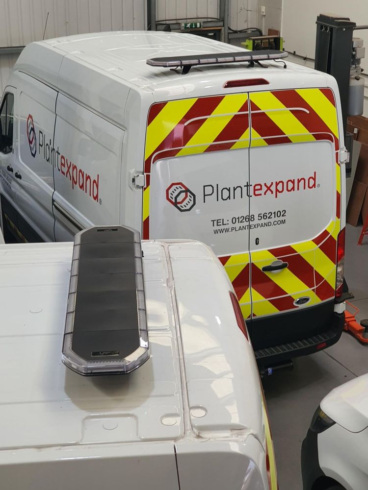Liveried vans fitted with beacon light bars inside the TAD Communications workshop in Hemel Hempstead